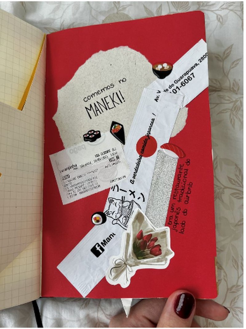 Caderno vermelho com recortes e lembranças de viagem